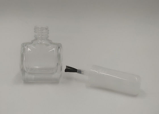 Botella del esmalte de uñas del maquillaje de la belleza con el cepillo blanco